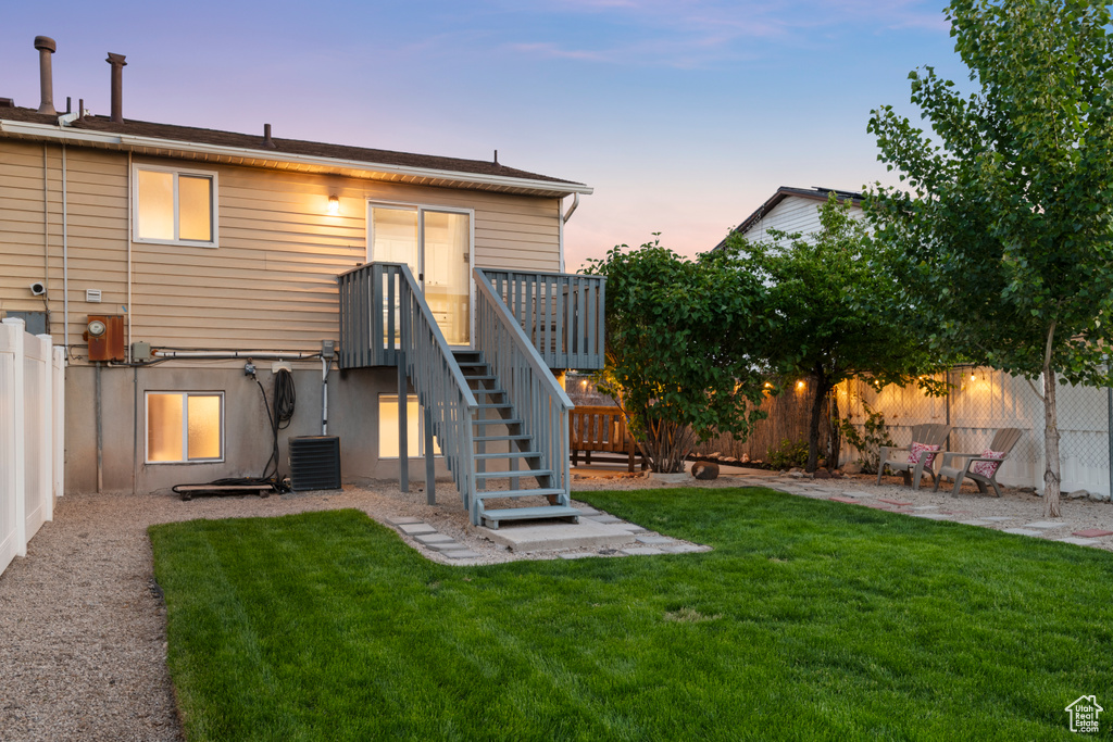 Back of property at dusk with central air condition unit