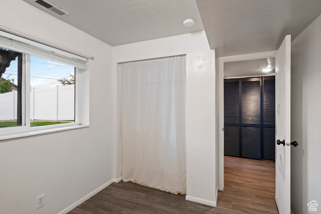 Unfurnished bedroom with dark wood-style floors and baseboards