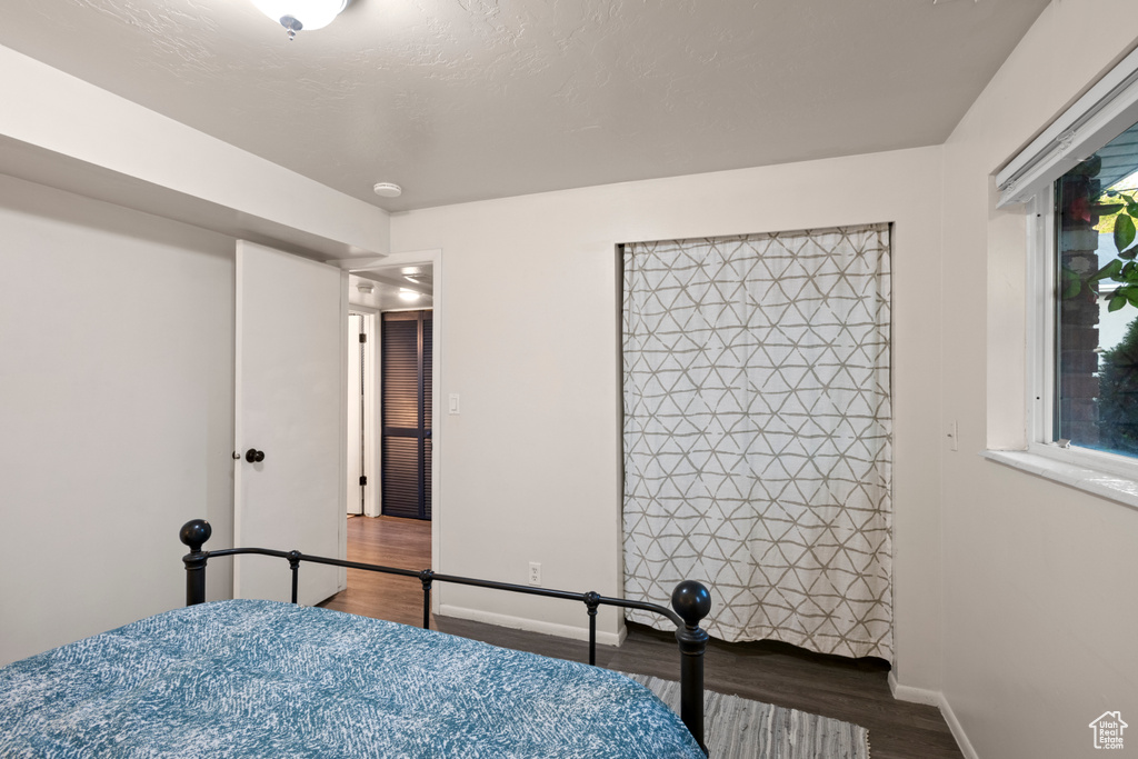 Bedroom with wood finished floors and baseboards