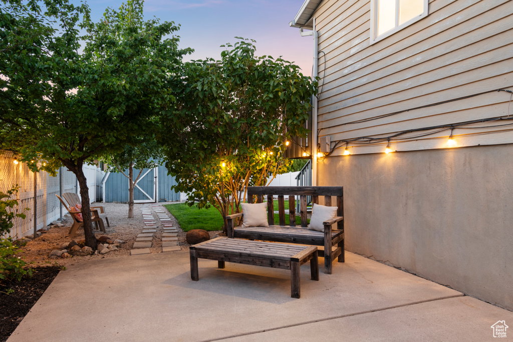 Patio terrace at dusk featuring a gate and a patio