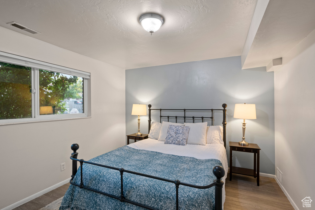 Bedroom with wood finished floors and baseboards
