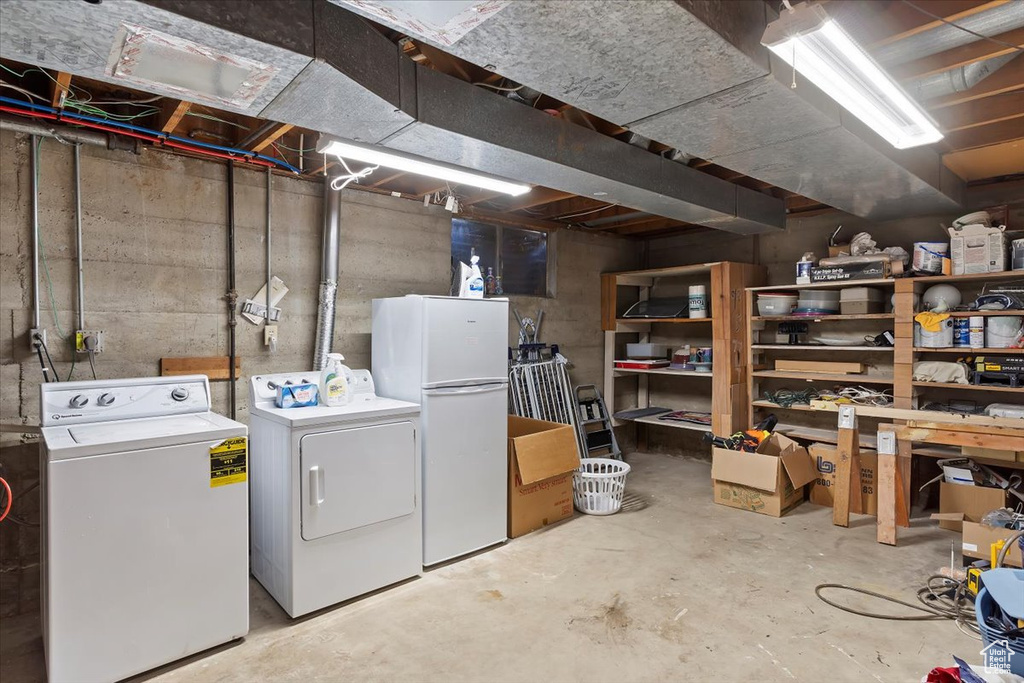 Unfinished below grade area with freestanding refrigerator and washing machine and dryer