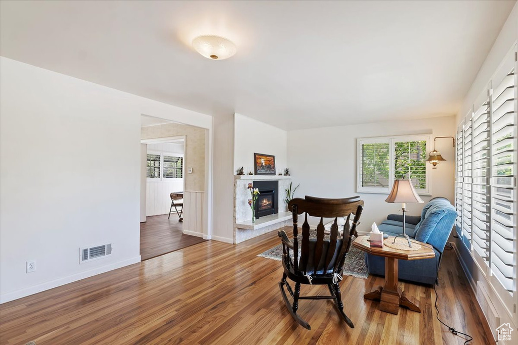 Sitting room featuring a glass covered fireplace, wood finished floors, and baseboards