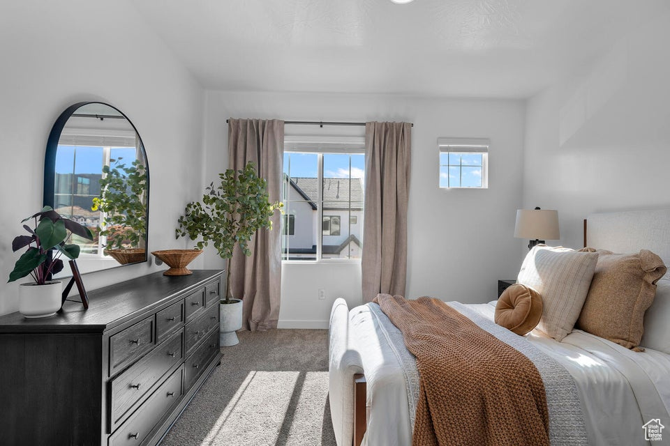 Bedroom featuring light carpet and baseboards