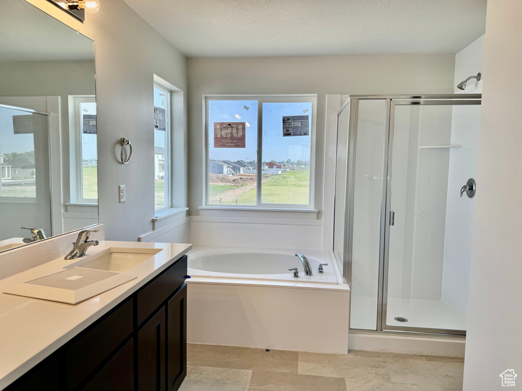 Bathroom with a stall shower, vanity, and a bath