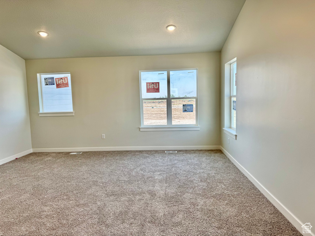 Carpeted empty room with healthy amount of natural light, baseboards, recessed lighting, and a textured ceiling