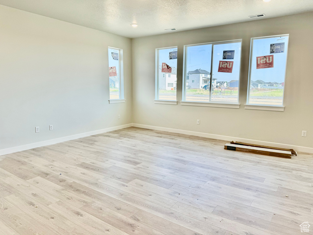 Unfurnished room with light wood-style flooring and baseboards