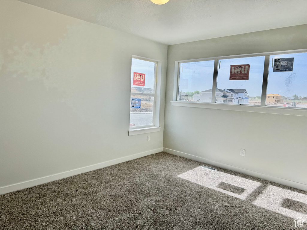 Empty room featuring carpet flooring and baseboards
