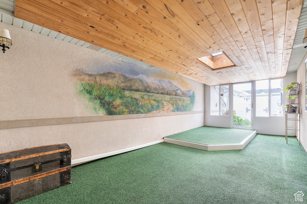 Playroom with carpet flooring, wood ceiling, a skylight, and a textured wall