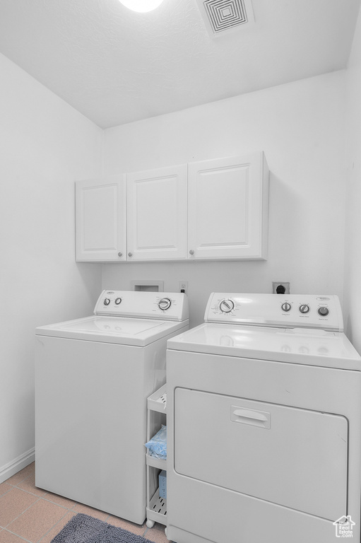 Washroom with cabinet space, independent washer and dryer, and baseboards