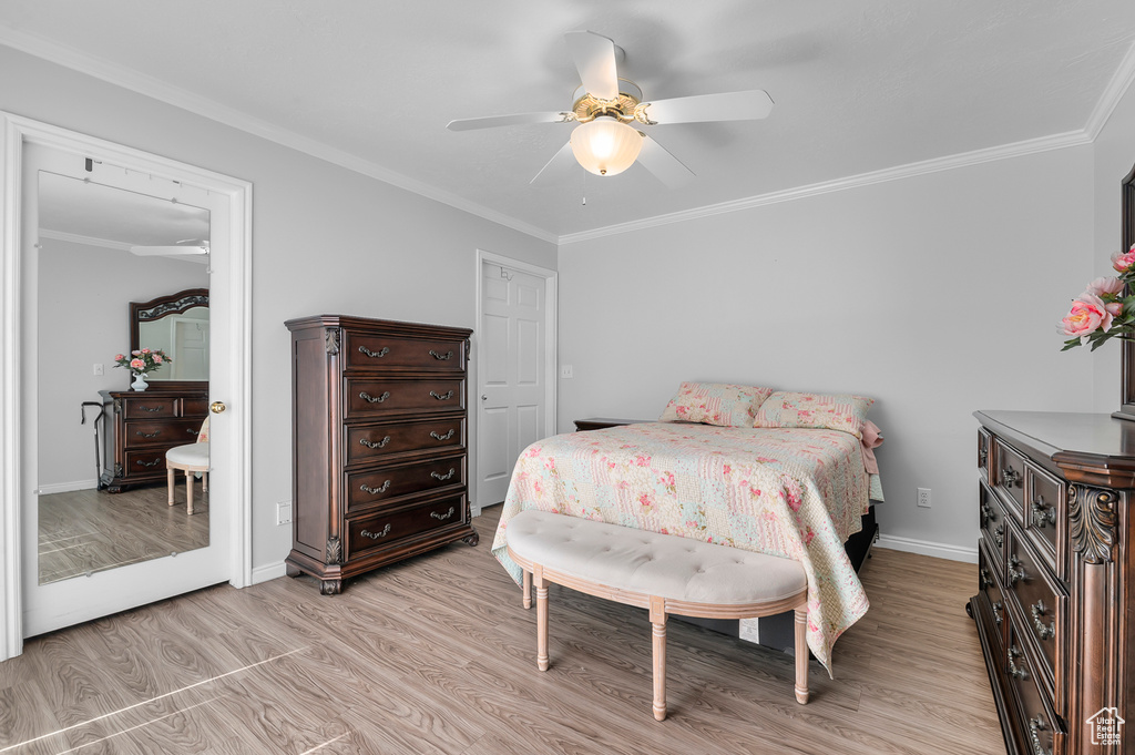 Bedroom featuring crown molding, light wood-type flooring, baseboards, and ceiling fan