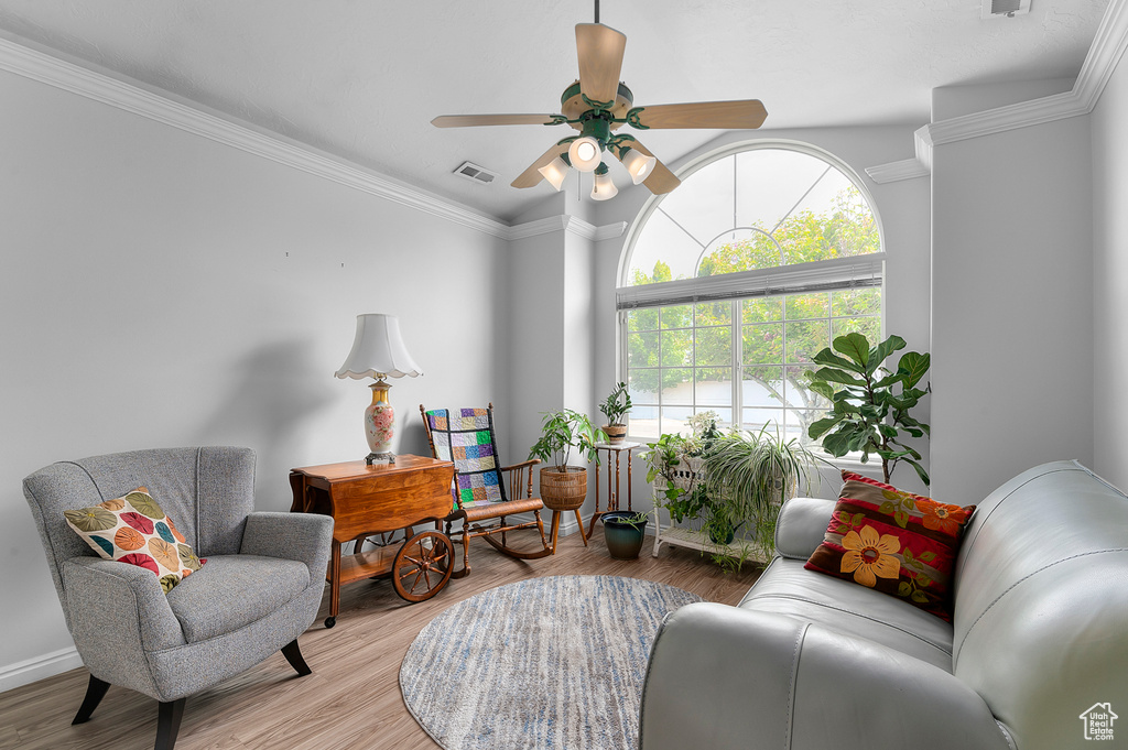 Sitting room featuring a ceiling fan, wood finished floors, and ornamental molding