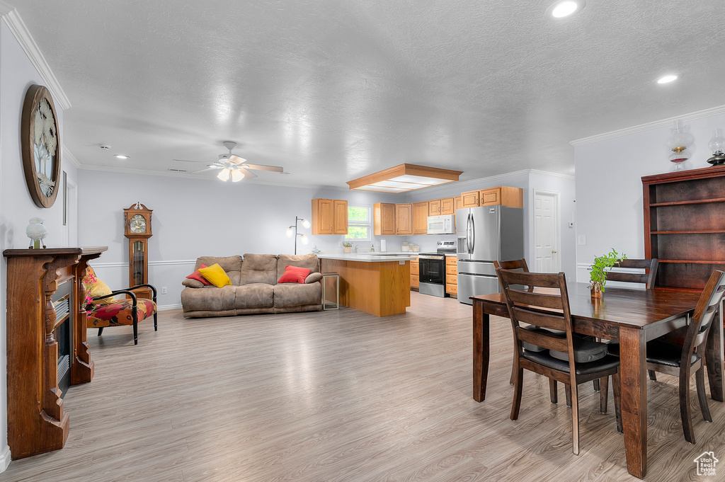 Dining area featuring light wood-type flooring, a ceiling fan, crown molding, recessed lighting, and baseboards