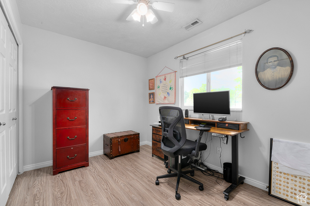 Office area with wood finished floors, a ceiling fan, and baseboards