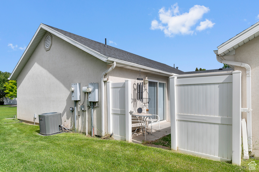 View of home's exterior featuring central AC, a yard, and stucco siding