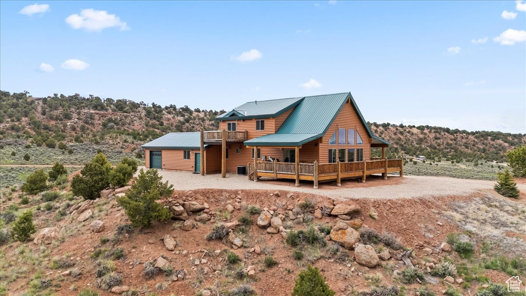 Rear view of property with log veneer siding, metal roof, and a deck