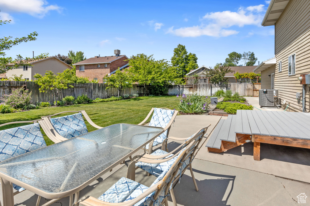 View of patio with outdoor dining space, cooling unit, and a residential view