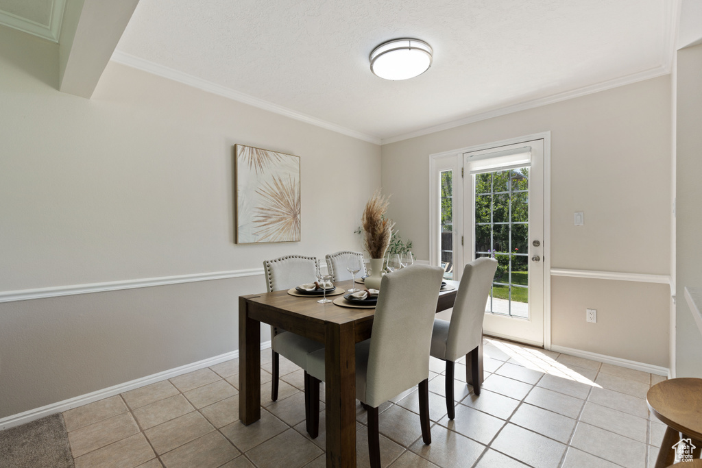 Dining area with baseboards, ornamental molding, and light tile patterned floors