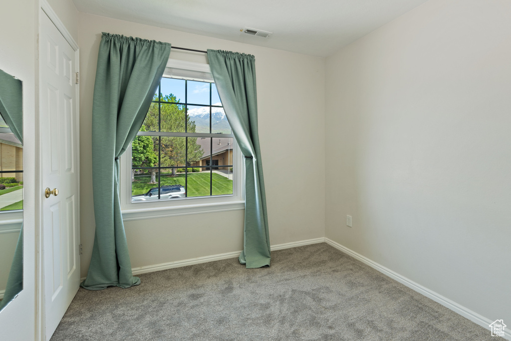 Carpeted empty room featuring baseboards