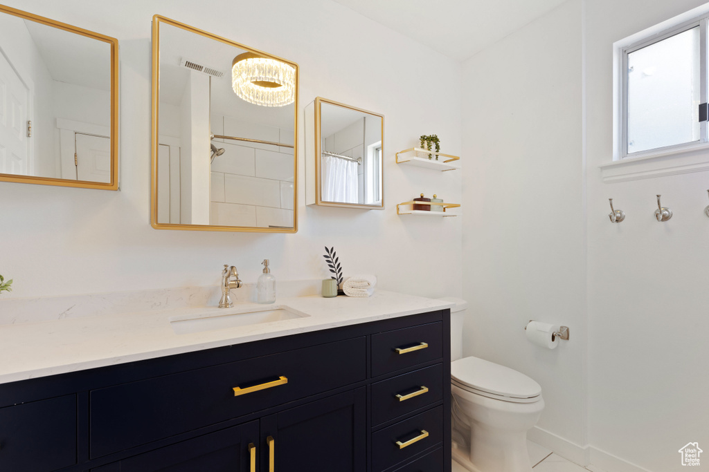 Bathroom featuring toilet, vanity, and a shower with shower curtain