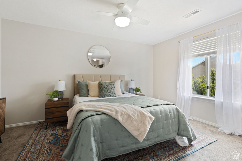 Carpeted bedroom with baseboards and a ceiling fan