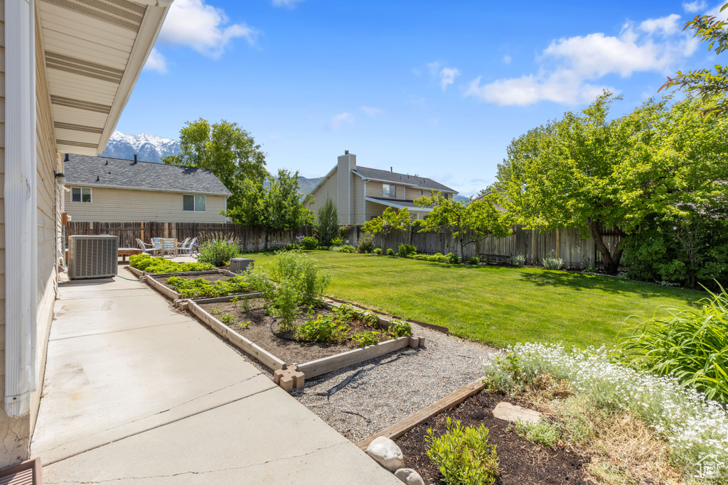 View of yard featuring a vegetable garden, central air condition unit, and a mountain view