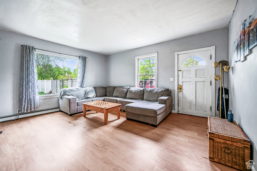 Living room with light wood finished floors and baseboard heating
