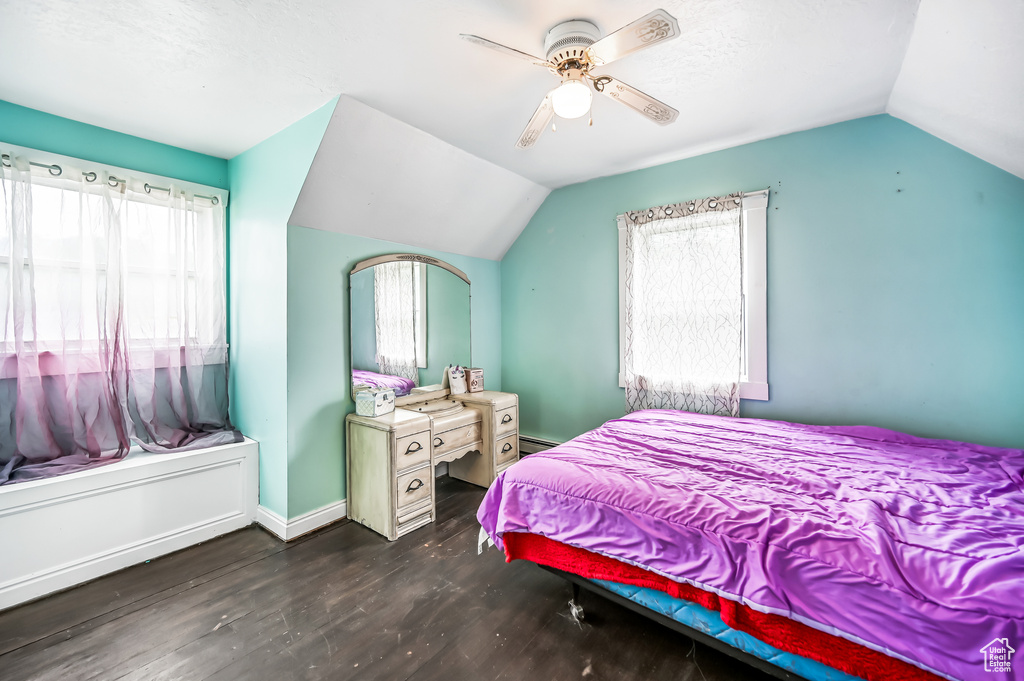 Bedroom with vaulted ceiling, wood finished floors, a ceiling fan, and baseboards