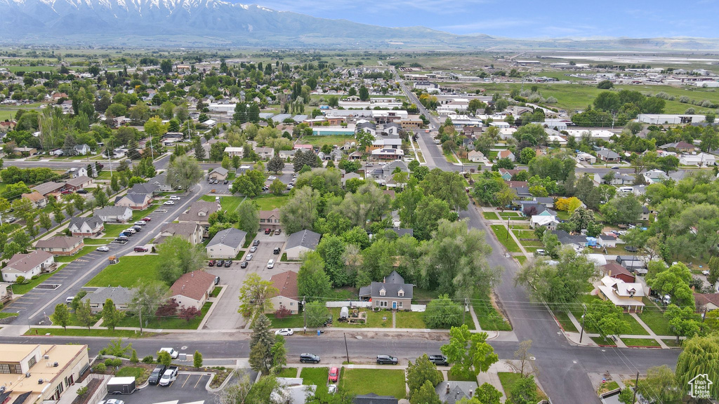 Aerial view of property and surrounding area with mountains and nearby suburban area
