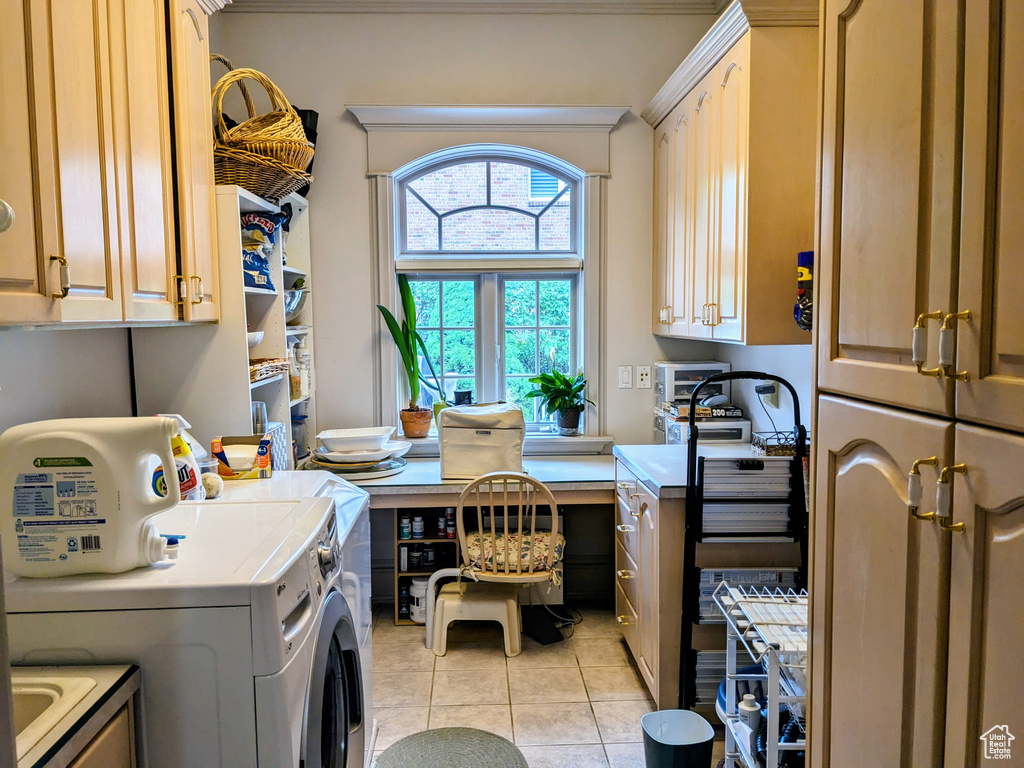 Laundry area with cabinet space, washing machine and dryer, and light tile patterned floors