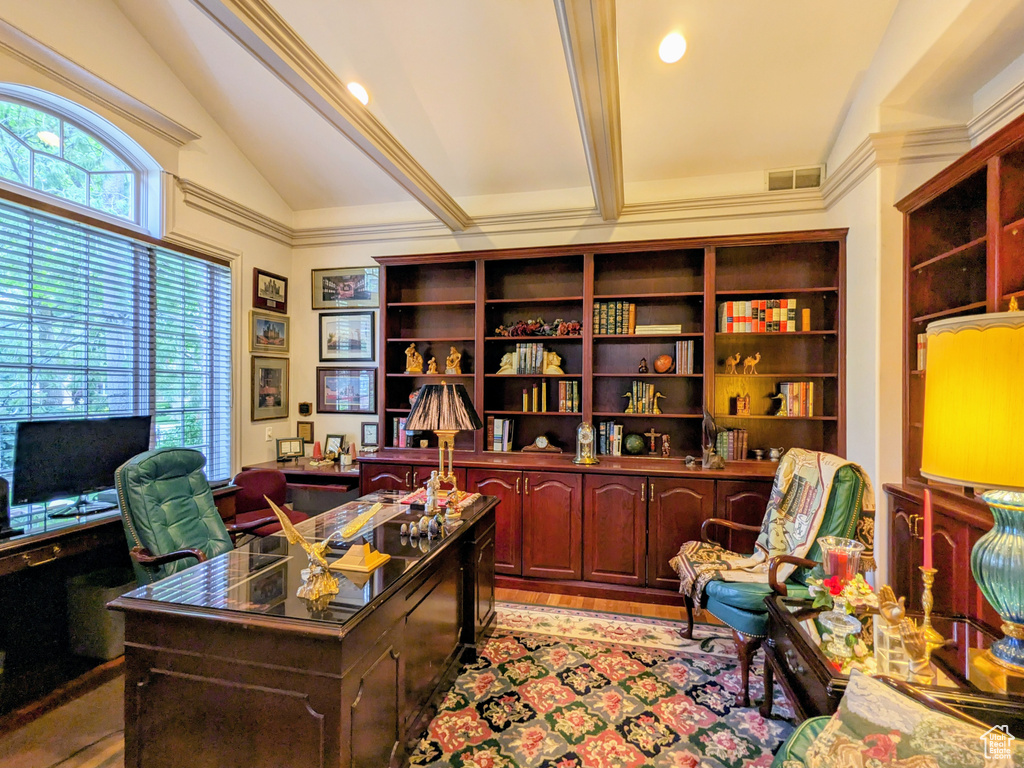 Home office featuring lofted ceiling, healthy amount of natural light, and light wood-type flooring