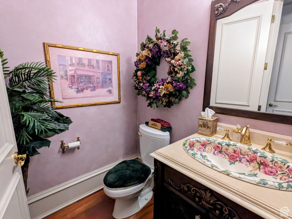 Bathroom featuring toilet, vanity, and wood finished floors