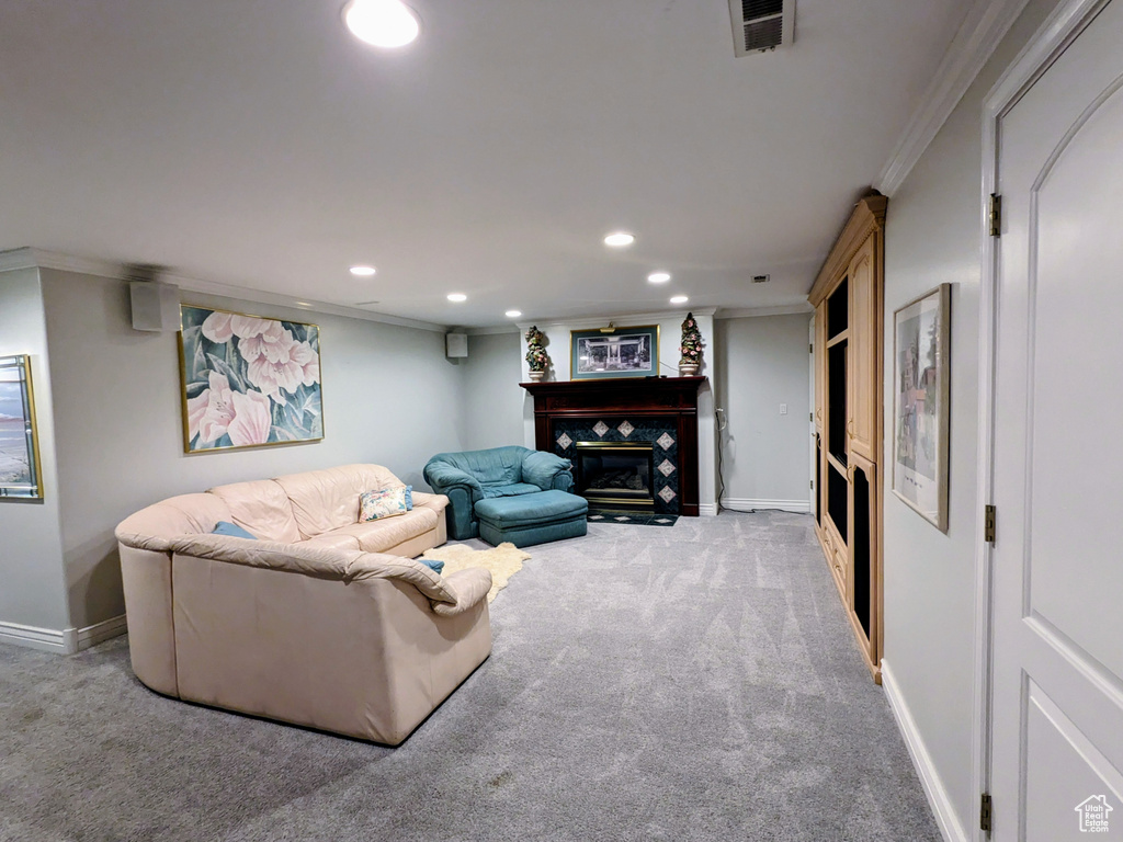 Carpeted living area featuring crown molding, a glass covered fireplace, recessed lighting, and baseboards