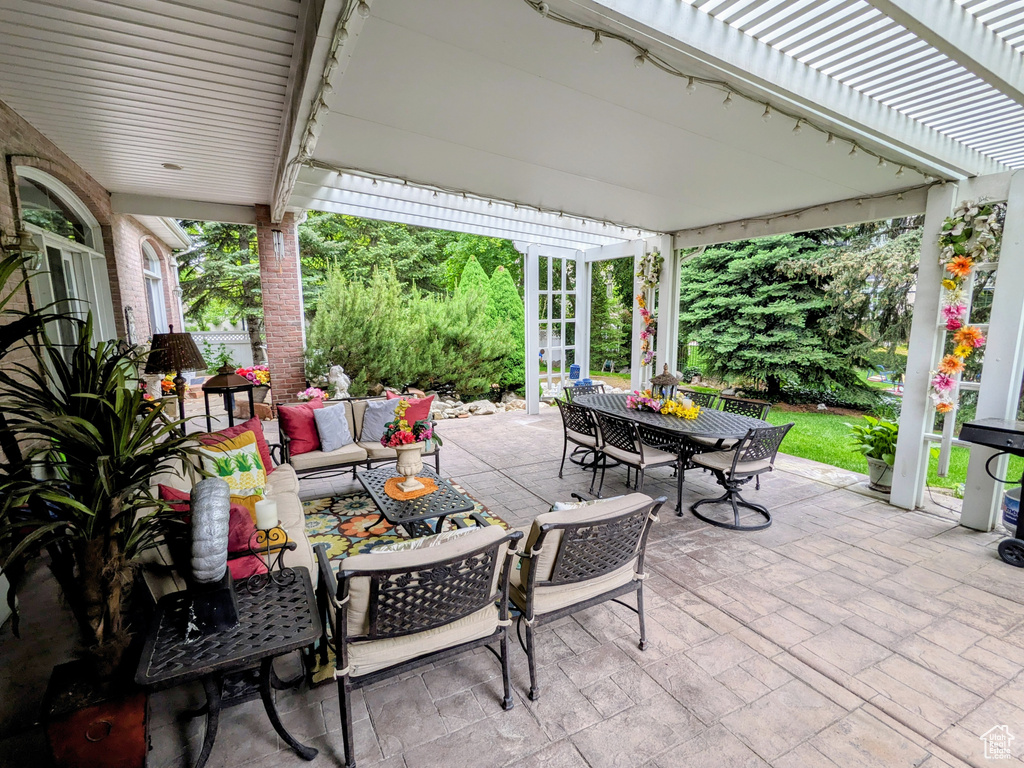 View of patio featuring outdoor dining space, a pergola, and an outdoor hangout area
