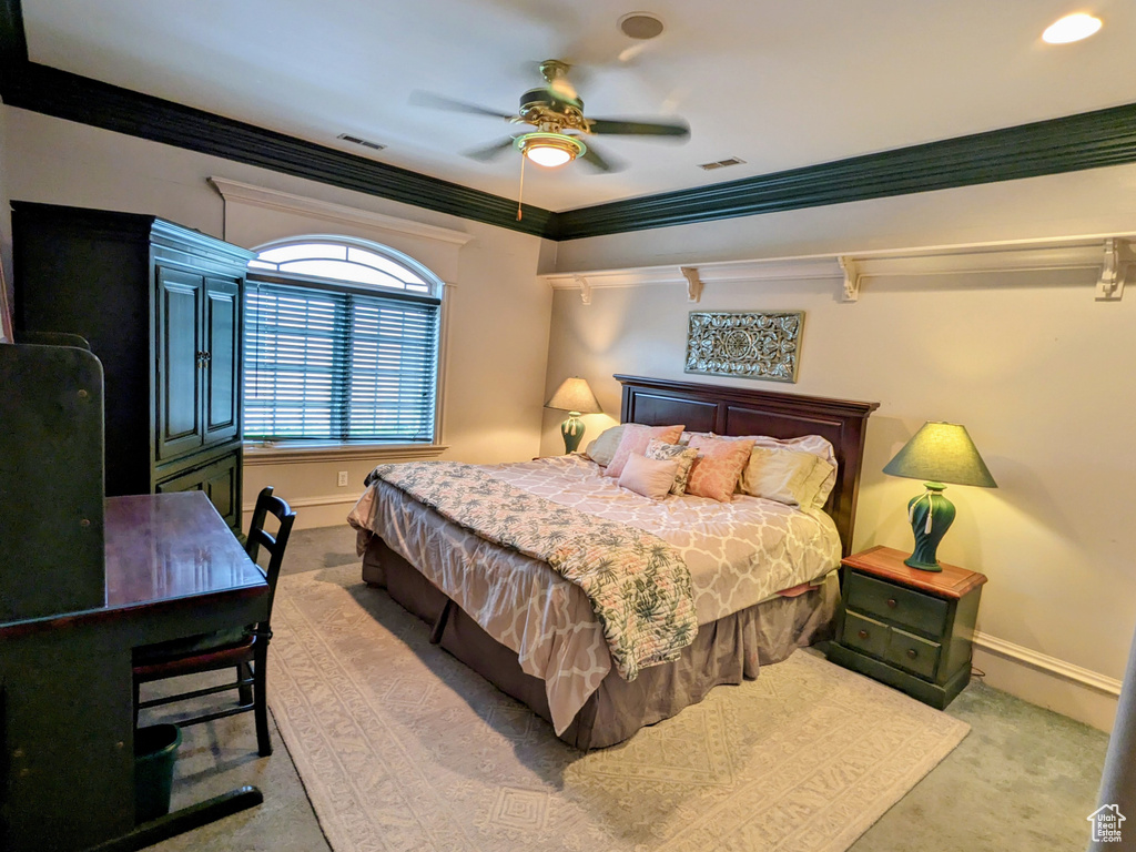 Carpeted bedroom with baseboards, crown molding, and ceiling fan