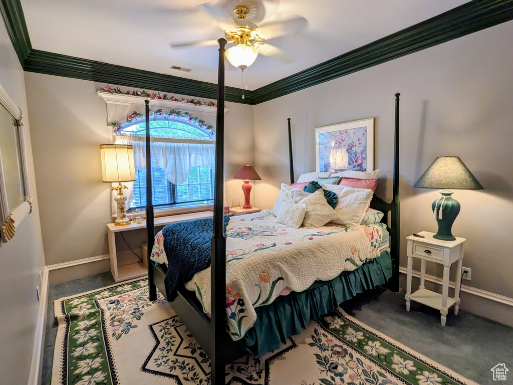 Carpeted bedroom featuring baseboards, ornamental molding, and a ceiling fan