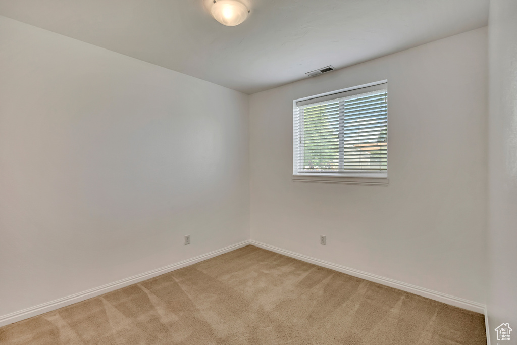 Spare room with light carpet and baseboards