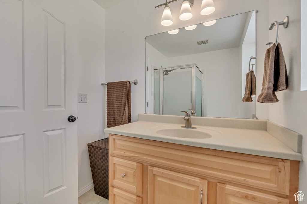 Full bath featuring vanity, a stall shower, and tile patterned flooring