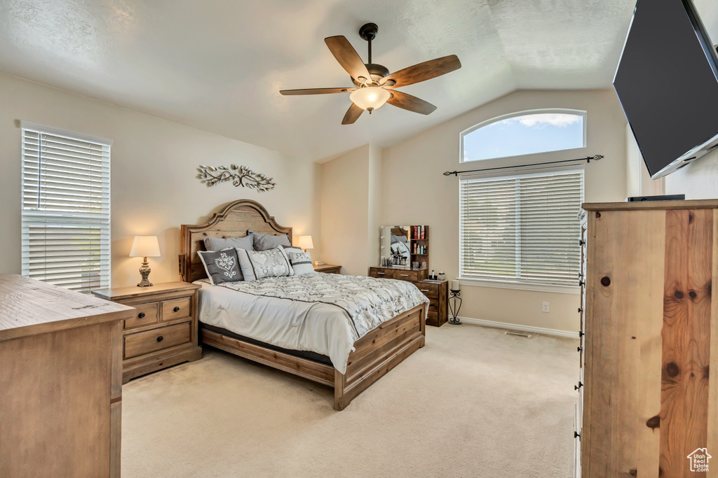 Bedroom featuring vaulted ceiling, light colored carpet, a ceiling fan, and baseboards