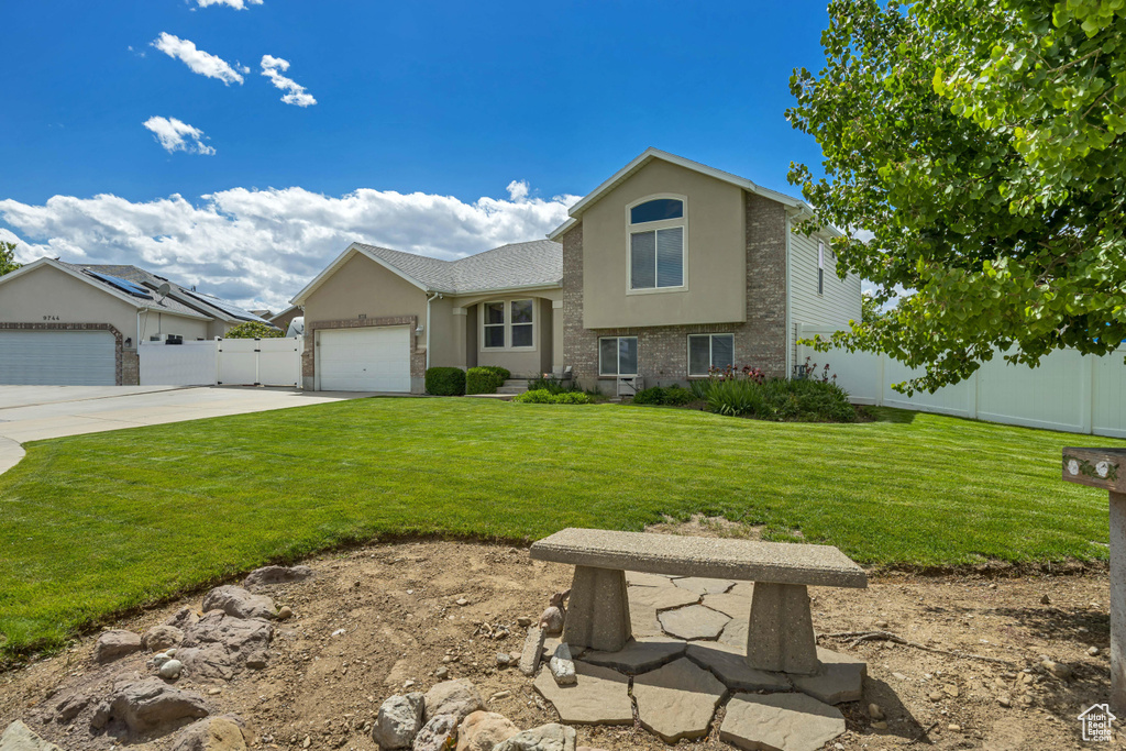Split level home featuring stucco siding, concrete driveway, and a garage