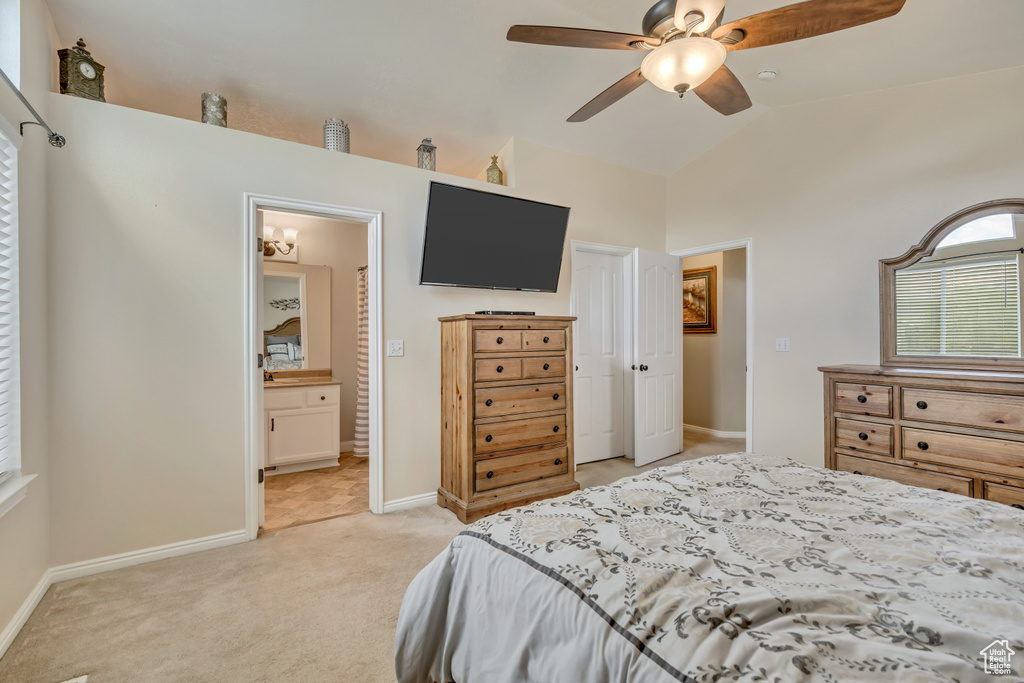 Bedroom featuring light colored carpet, baseboards, connected bathroom, ceiling fan, and high vaulted ceiling
