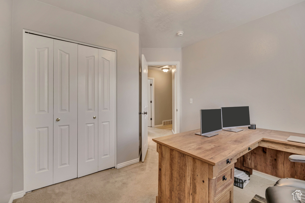 Home office featuring light colored carpet and baseboards
