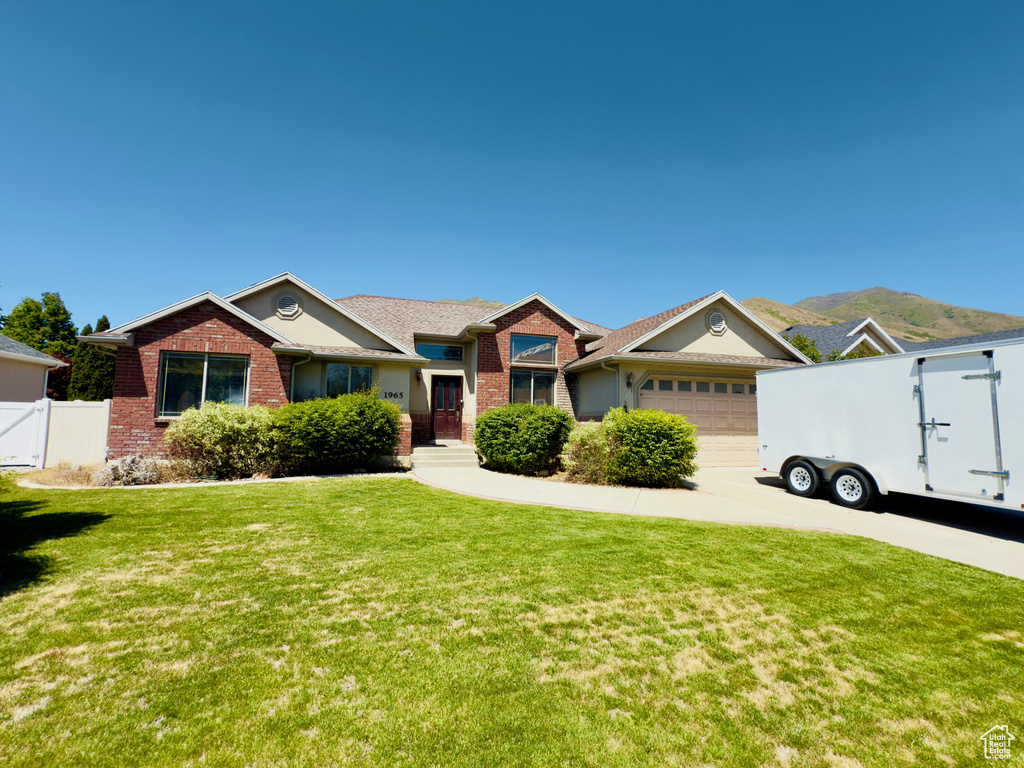 Single story home with brick siding, a garage, concrete driveway, and a gate
