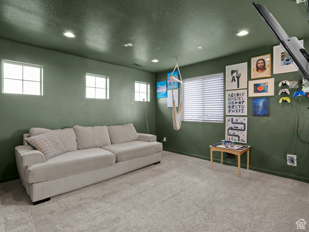 Carpeted living room featuring recessed lighting, a textured ceiling, and baseboards