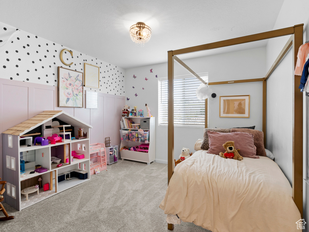 Bedroom with carpet flooring, a chandelier, and wallpapered walls