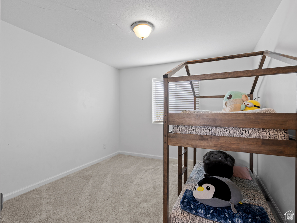 Bedroom featuring carpet and baseboards
