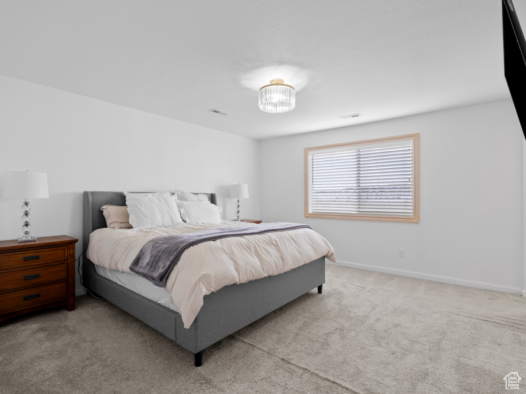 Bedroom with light carpet and baseboards