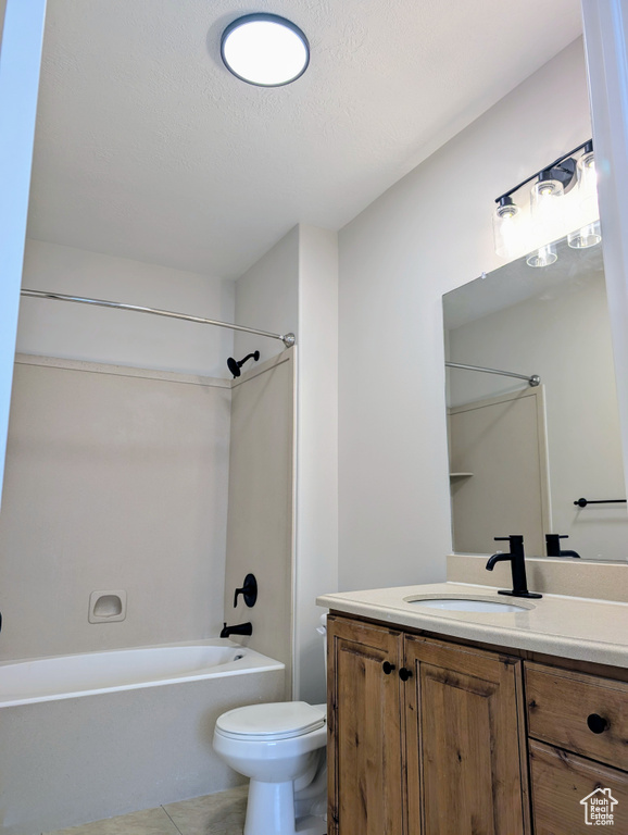 Full bathroom with toilet, vanity, tub / shower combination, a textured ceiling, and tile patterned floors