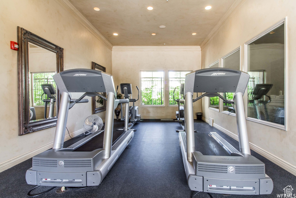 Workout room featuring plenty of natural light, crown molding, baseboards, and recessed lighting