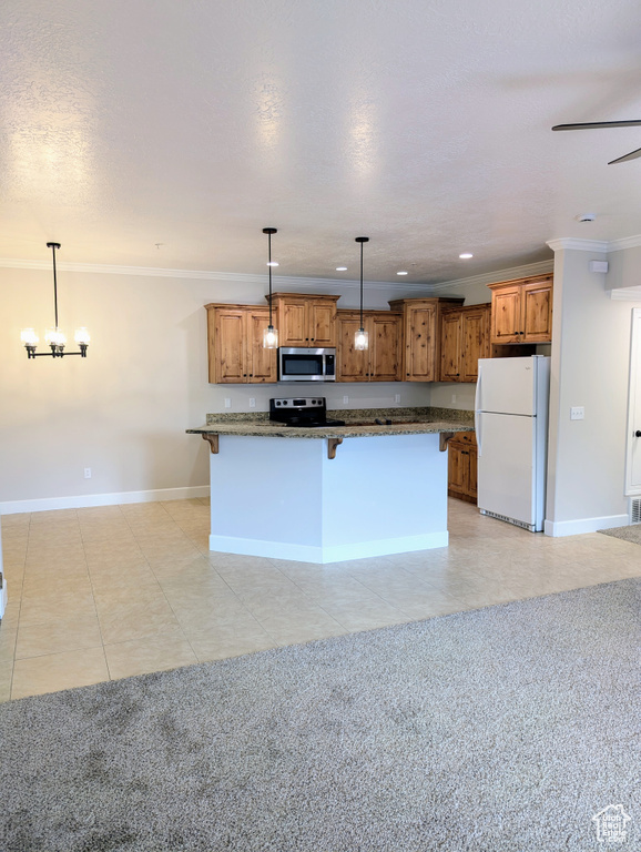 Kitchen featuring stainless steel appliances, crown molding, a breakfast bar, brown cabinets, and baseboards
